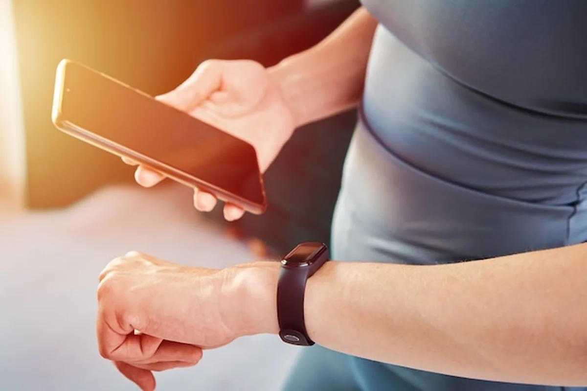 Kobieta używa monitora fitness podczas ćwiczeń w domu