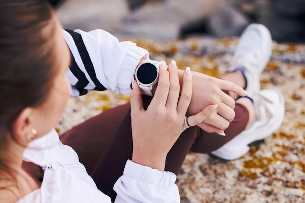 Fitness kobieta z inteligentnym zegarkiem podczas górskich wędrówek